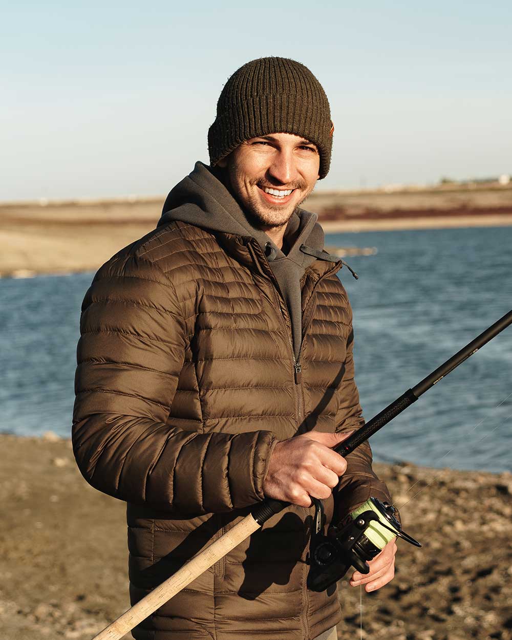 young fisherman standing on the shore of lake with SYP35DE